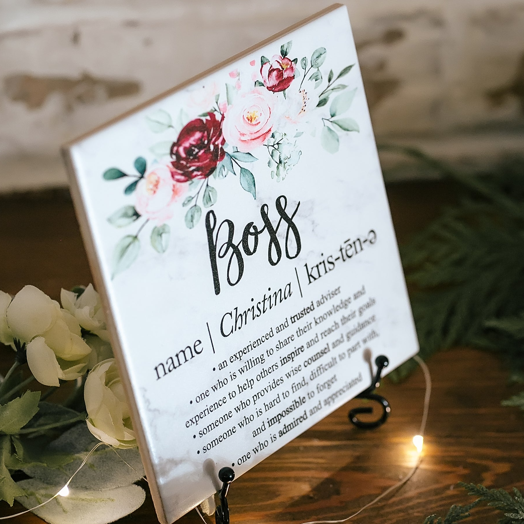 a close up of a sign on a table with flowers