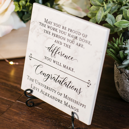 a sign on a table with flowers in the background