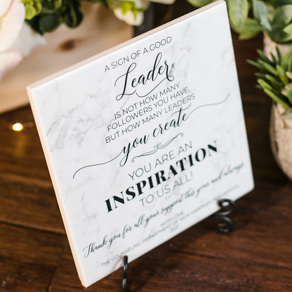 a sign on a table with flowers in the background